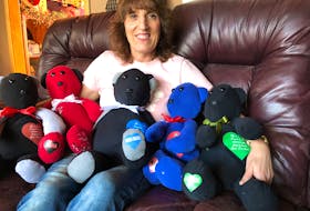 Denise Roy Patton poses with some of the memory bears she has made for family, friends and strangers in the last year.