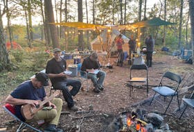 Volunteers relax at the camp fire after a day of working to protect old growth hemlocks in the Tobeatic. CONTRIBUTED 