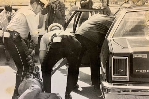 Bob Wakeham is dragged away by Royal Newfoundland Constabulary officers 40 years ago. Wakeham was among the Evening Telegram employees on strike at the time. The building fronted on Duckworth Street and backed on Water Street.