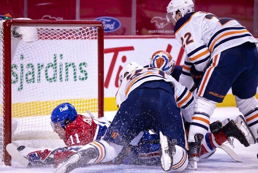 Montreal Canadiens right wing Brendan Gallagher (11) crashes into the net after diving across Edmonton Oilers goaltender Mikko Koskinen (19) to score the Canadiens third goal during NHL action in Montreal on Tuesday, March 30, 2021. 