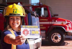 Angie Arsenault, a volunteer firefighter with the New London Fire Department, holds a promotional card for a weekly P.E.I. fundraiser.