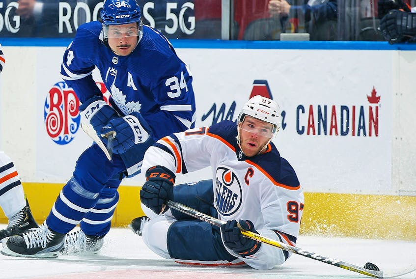 Connor McDavid of the Edmonton Oilers battles for the puck against Auston Matthews of the Toronto Maple Leafs at Scotiabank Arena on March 29, 2021 in Toronto. 