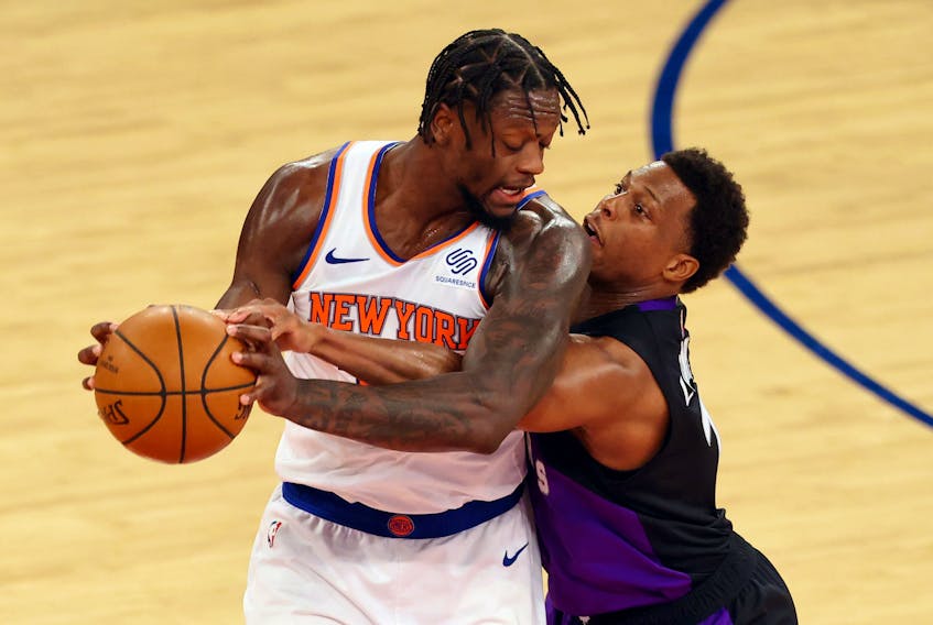 Julius Randle of the Knicks (left) is guarded by Raptors' Kyle Lowry during their game at Madison Square Garden on April 11, 2021 in New York City. 