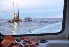 The dredger, seen here from inside Chris Wall's boat, is on site at Malpeque harbour, though Wall didn't know if dredging had started yet.