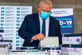 Ontario Premier Doug Ford examines COVID-19 Rapid Test Device kits at Humber River Hospital in Toronto on Nov. 24, 2020.  