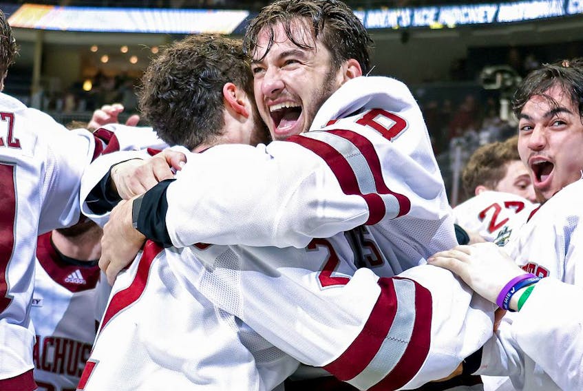 Jake Gaudet celebrates with teammate Marc Del Gaizo (No. 2) of the Massachusetts Minutemen after a 5-0 victory over the St. Cloud St. Huskies at PPG Paints Arena on April 10, 2021, in Pittsburgh.