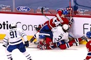 Canadiens' Joel Edmundson (44) and Maple Leafs' Justin Holl fall on Habs' Josh Anderson and Leafs' John Tavares during the second period at the Bell Centre in Montreal on Monday, April 12, 2021. 