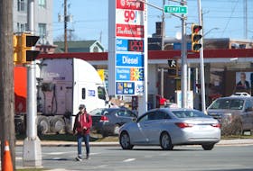 A man walks across Young Street as a car prepares to make a left-hand turn from Kempt Road in Halifax Monday April 12, 2021. Coun. Waye Mason wants the municipality to consider options for establishing protected left-turn and right-turn movements at intersections with high traffic and pedestrian volumes like the Young Street and Kempt Road intersection, where David Gass was struck by a vehicle last month and died of his injuries shortly after.