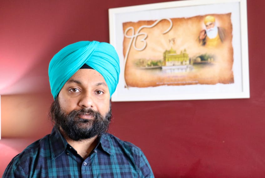 Savneet Singh Malhotra stands in front of a picture of the Harmandir Sahib – or Golden Temple – a gurdwara in India which serves free meals to 100,000 people each day.