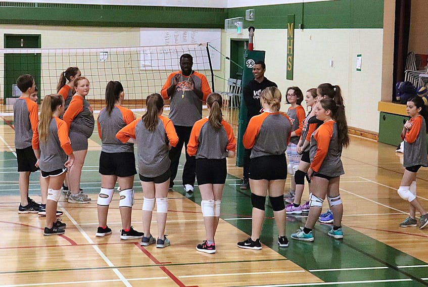 In this 2019 photo, Ebou Secka, executive director for the Volleyball Cape Breton Association, middle, speaks with young players during a practice at Memorial High School gym in Sydney Mines. It’s been a challenging year both on and off the court for the volleyball association, but programming hasn’t slowed down. CONTRIBUTED