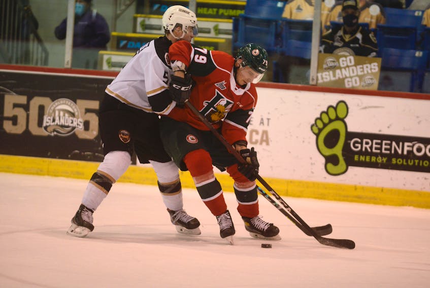 Halifax Mooseheads defenceman Jason Horvath, right, tries to spin away from the forecheck of Braeden Virtue of the Charlottetown Islanders Tuesday in Charlottetown.