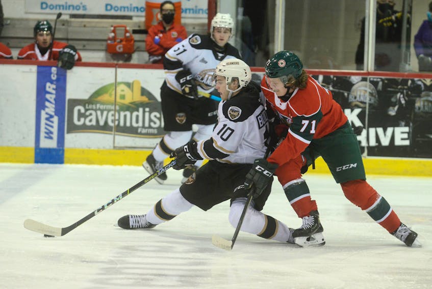Charlottetown Islanders captain Brett Budgell, left, tries to get the puck to a teammate while fending off the check of Halifax Mooseheads centre Attilio Biasca Tuesday at the Eastlink Centre in Charlottetown.