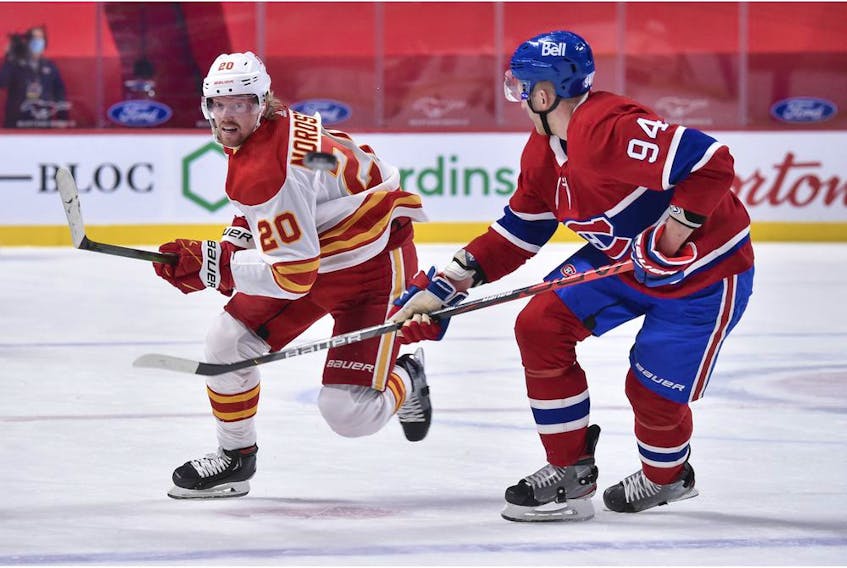Joakim Nordstrom of the Calgary Flames and Corey Perry of the Montreal Canadiens chase the puck during the first period at the Bell Centre on April 14, 2021 in Montreal, Canada.