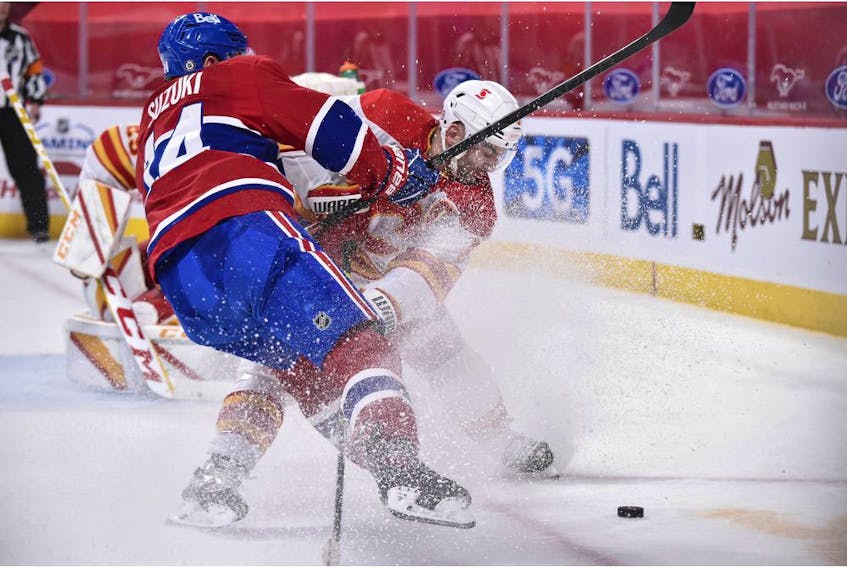  Nick Suzuki of the Montreal Canadiens and Mark Giordano of the Calgary Flames chase the puck during the second period at the Bell Centre on April 14, 2021 in Montreal, Canada.
