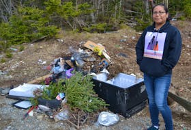 Eskasoni resident Leah Doucette stands next to a pile of garbage near where she picks medicinal plants on Mountain Road. ARDELLE REYNOLDS/CAPE BRETON POST