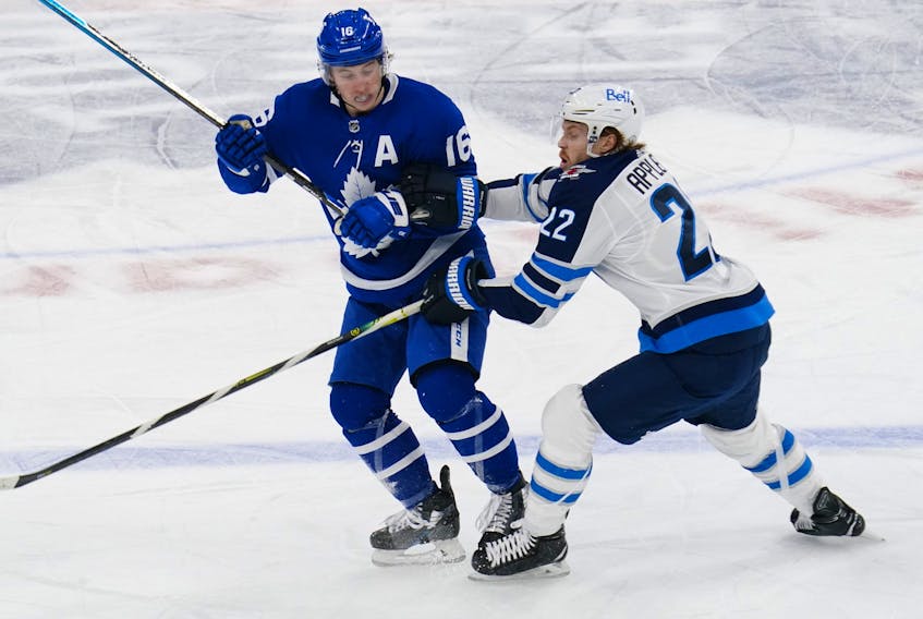 Toronto Maple Leafs forward Mitchell Marner tries to avoid a check from Winnipeg Jets forward Mason Appleton on Thursday night.
