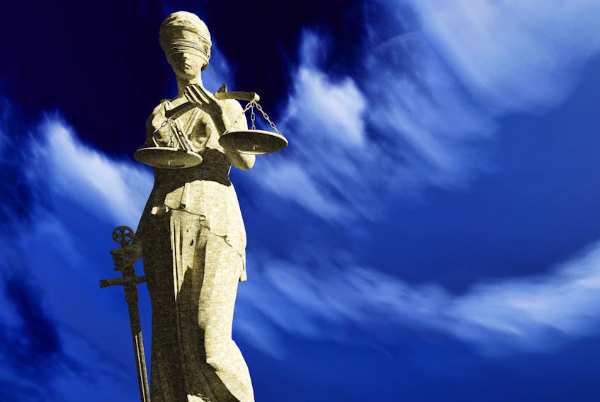 A Lady Justice sculpture depicts a blindfolded woman with sword and scale
