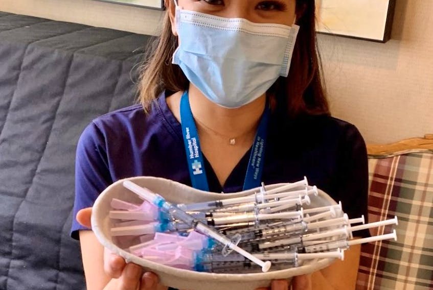 Humber River Hospital nurse Brenda Lotakoun, part of the hospital's mobile vaccination unit, holds Moderna vaccines ready for residents of Richview highrise