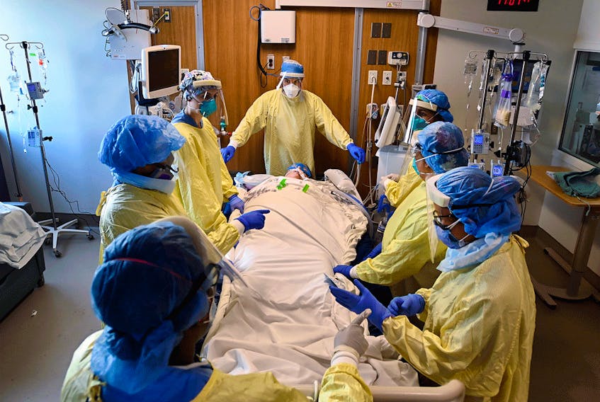 Healthcare workers get ready to prone a 47-year-old woman who has COVID-19 and is intubated on a ventilator in the intensive care unit at Toronto's Humber River Hospital on Tuesday, April 13, 2021.