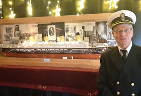 Dressed in a ship captain's uniform, Ray Johnson poses in front of the scale model of the Titanic that took him a dozen years to build. — Facebook/Pauline Yetman