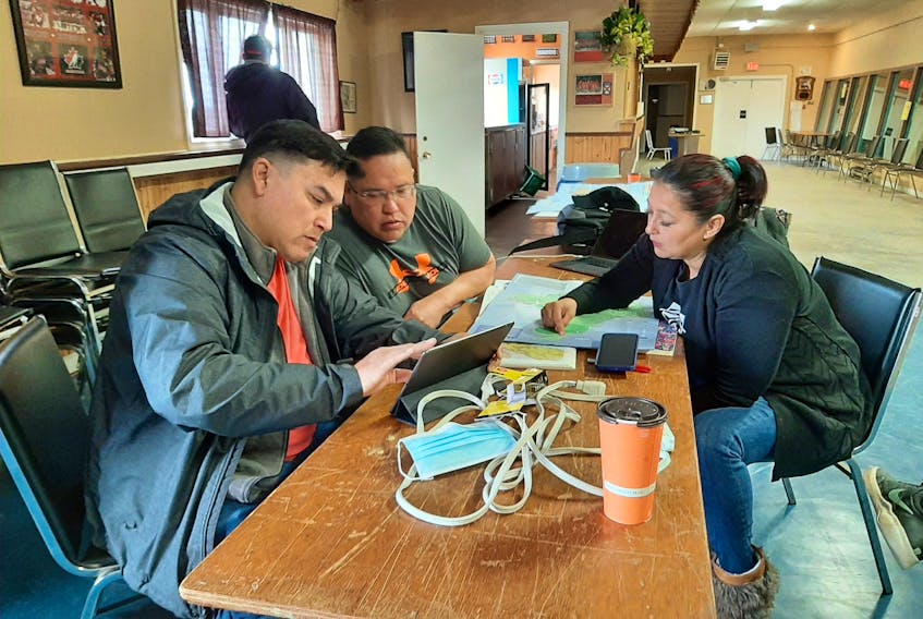 Josh Augustine and Richard Levi from Elsipogtog First Nation and Starr Paul from Eskasoni First Nation look at maps of the Cape Breton coastline as part of the search for Jumbo Sock. ARDELLE REYNOLDS/CAPE BRETON POST