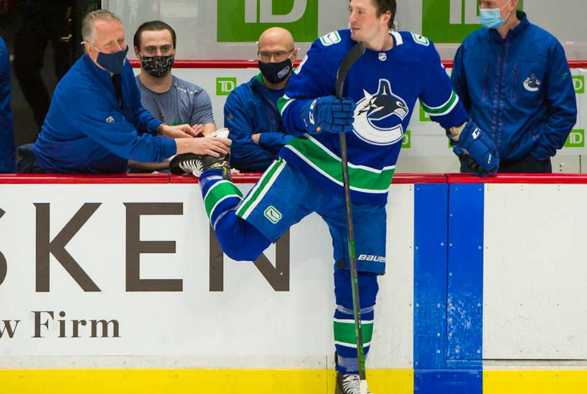 J.T. Miller gets his skate worked on by Canucks equipment manager Pat O'Neill before playing Ottawa on Jan. 27, 2021. 