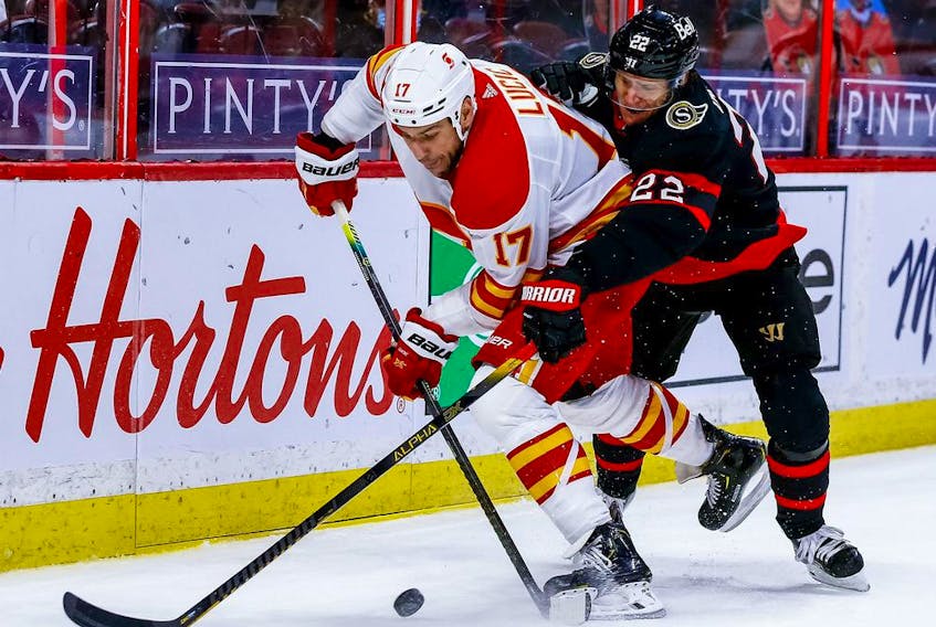 The Calgary Flames’ Milan Lucic battles the Ottawa Senators’ Nikita Zaitsev at the Canadian Tire Centre in Ottawa on March 24, 2021. 