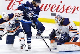 Edmonton Oilers defenseman Tyson Barrie (22) and Winnipeg Jets left wing Kyle Connor (81) jump from the puck in front of Edmonton Oilers goaltender Mike Smith (41) in the second period at Bell MTS Place on April 17, 2021. 