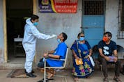  A health worker takes a swab sample of a resident for a COVID-19 test at a medical centre in Dharavi slums in Mumbai on April 17, 2021.