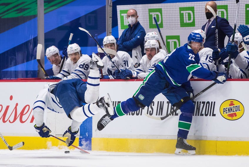 Vancouver Canucks' Alexander Edler, right, of Sweden, and Toronto Maple Leafs' Zach Hyman collide during the second period of an NHL hockey game in Vancouver, B.C., Sunday, April 18, 2021. Edler received a major penalty for kneeing and a game misconduct on the play.  