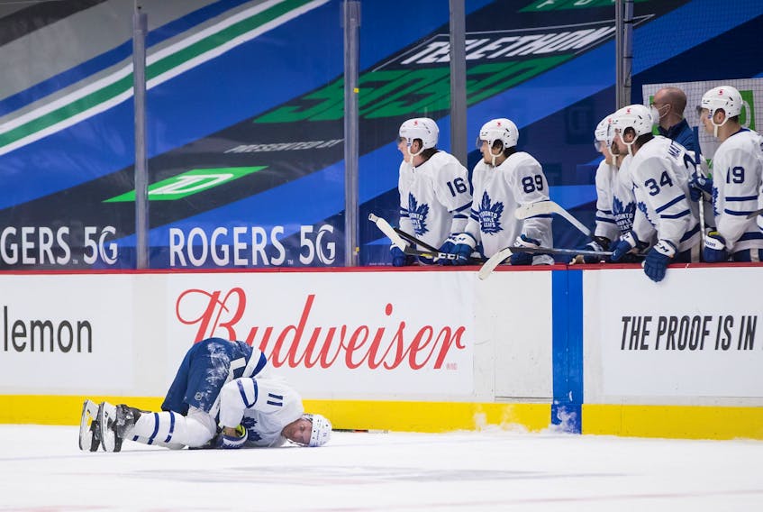  Toronto Maple Leafs’ Zach Hyman lies on the ice after colliding with Vancouver Canucks’ Alexander Edler during the second period of an NHL hockey game in Vancouver, B.C., Sunday, April 18, 2021.