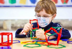  A child plays with colourful plastic blocks kit in a childcare environment.