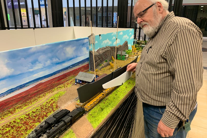 Ron Furlong places a cut-out of a sailing ship on the back of a locomotive at the Cumberland Area Railway Club at the Amherst Centre mall. Furlong is proposing an interpretive centre and display at the Nova Scotia border in Fort Lawrence, celebrating the Chignecto Marine Ship Railway.
