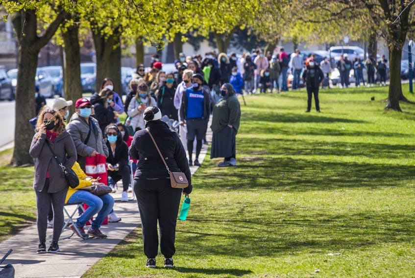 A lineup, that at one point stretched for about 1.5 km, for a Mobile Vaccine Clinic at Parkway Forest Community Centre near Sheppard Ave. E., and Don Mills Rd. in Toronto, on Monday April 19, 2021.  
