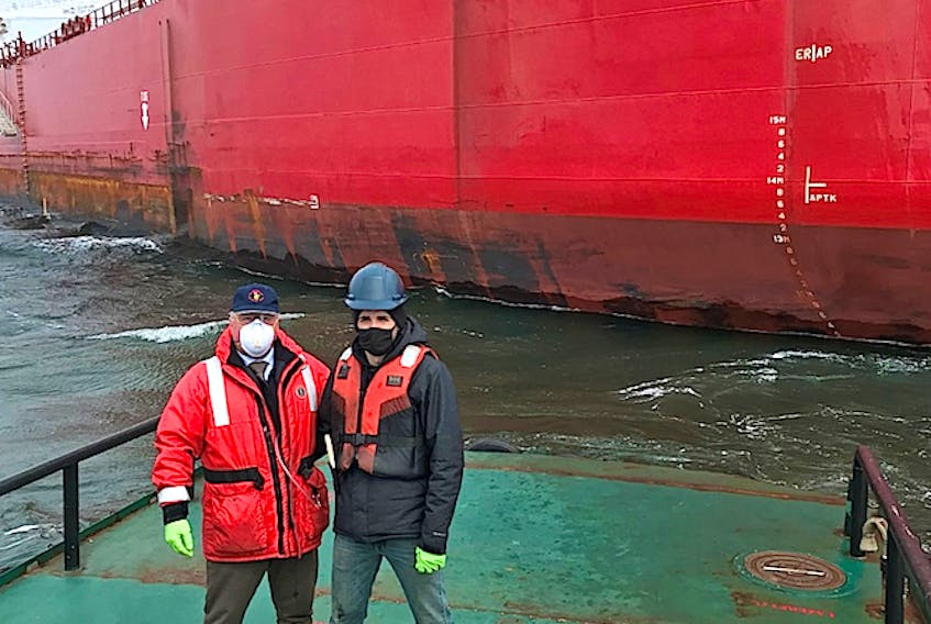 Iaian Langley, left, a harbour pilot with the Atlantic Pilotage Authority, and Greg Cogswell, a deckhand, on the harbour launch, a work boat that services the harbour, after delivering the care package to the STI San Telmo which is anchored off Port Hawkesbury, Tuesday. CONTRIBUTED 