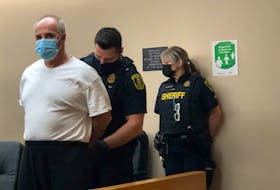 Sheriff's officers at provincial court in St. John's escort Dennis Peter Murphy, 60, into the courtroom for his sentencing hearing Wednesday. 