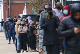 A lineup of people going on for rapid COVID-19 testing starts at the front door on Argyle Street and wraps around Sackville Street and Market Street in downtown Halifax Thursday.