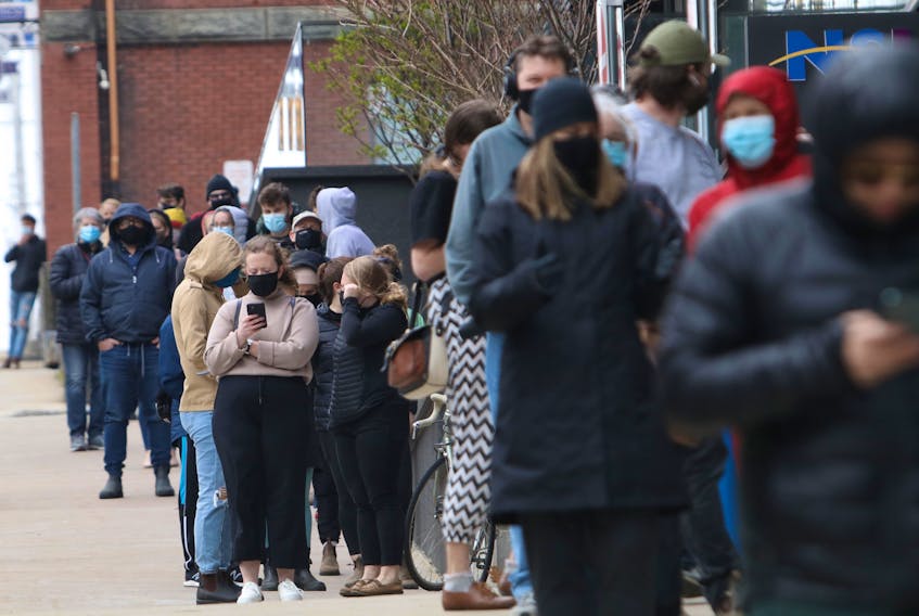 A lineup of people going on for rapid COVID-19 testing starts at the front door on Argyle Street and wraps around Sackville Street and Market Street in downtown Halifax Thursday.