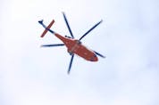  An Ornge emergency transport helicopter flies through the downtown Toronto core on March 27, 2021.
