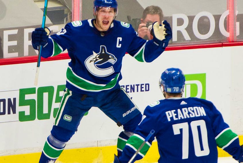  Canucks captain Bo Horvat celebrates his second-period goal against the Toronto Maple Leafs with linemate Tanner Pearson on Sunday.
