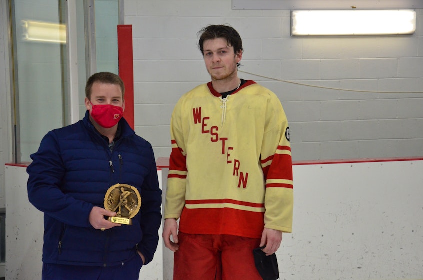 Island Junior Hockey League commissioner Jordan Ellis, left, presents Arsenault’s Fish Mart Western Red Wings forward Silas Handrahan with the MVP award for the playoffs. Handrahan recorded 20 points and had at least one point in eight of the Red Wing’s nine post-season games. The Red Wings defeated the Sherwood-Parkdale A&S Scrap Metal Metros 6-1 on Wednesday night to clinch the franchise’s fourth straight provincial title. - Jason Simmonds