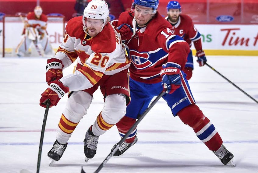 MONTREAL, QC - APRIL 14:  Nick Suzuki #14 of the Montreal Canadiens challenges Joakim Nordstrom #20 of the Calgary Flames during the third period at the Bell Centre on April 14, 2021 in Montreal, Canada.  The Flames defeated the Canadiens 4-1.