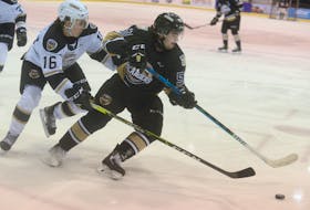 Charlottetown Islanders Team Black defenceman Lukas Cormier, right, spins away from Charlottetown Islanders Team White forward Pat Guay during Wednesday’s intrasquad game at Eastlink Centre.