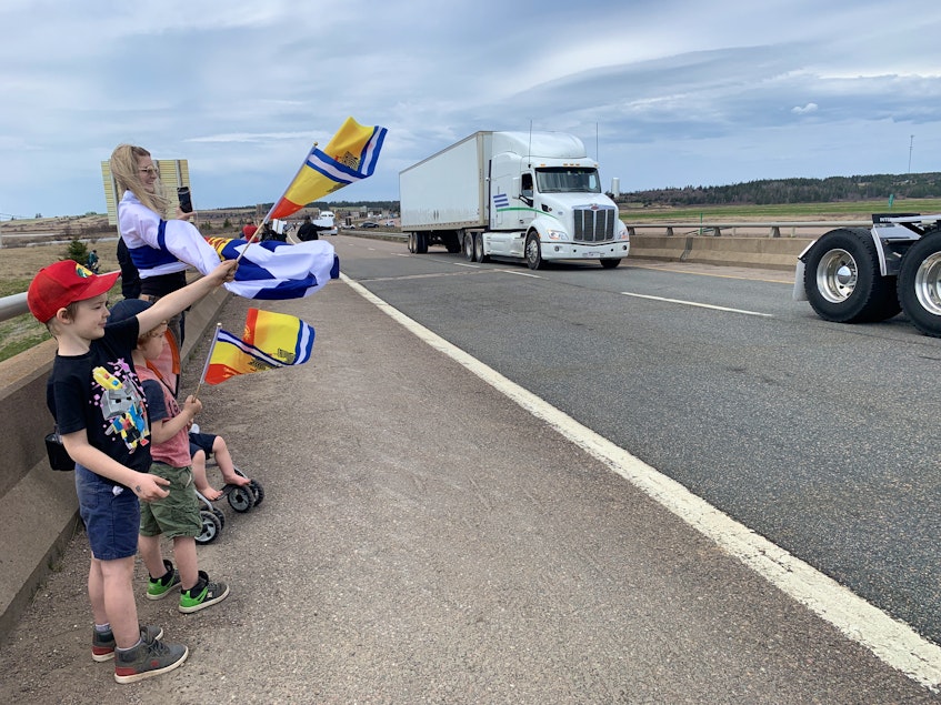 Sarah LeBlanc and her children (from left) five-year-old Cameron, four-year-old Barrett and 14-month-old Isiah wave to traffic crossing into Nova Scotia following a blockade at the border on Sunday afternoon. - Darrell Cole / SaltWire Network