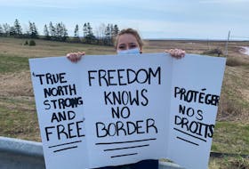 Maria Allen holds up a sign during a protest at the Nova Scotia border on Sunday afternoon. Darrell Cole - SaltWire Network