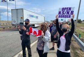 Protesters hold up signs at the entrance to Nova Scotia during a rally at the border in Fort Lawrence, N.S. Darrell Cole - SaltWire Network