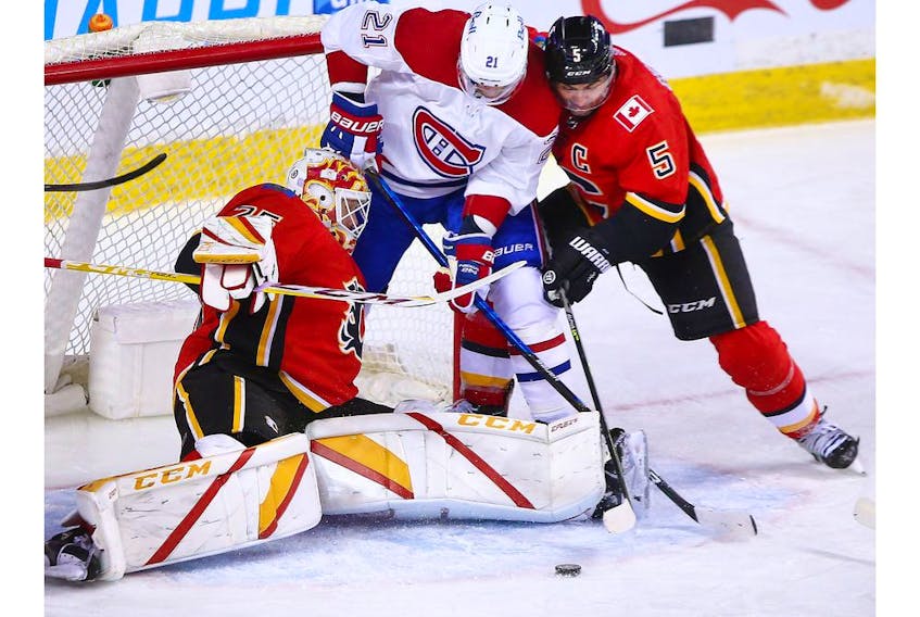 Calgary Flames goaltender Jacob Markstrom and Flames captain Mark Giordano struggle with the Montreal Canadiens' Eric Staal and a loose puck during NHL action at the Scotiabank Saddledome in Calgary on Saturday, April 24, 2021. 

Gavin Young/Postmedia