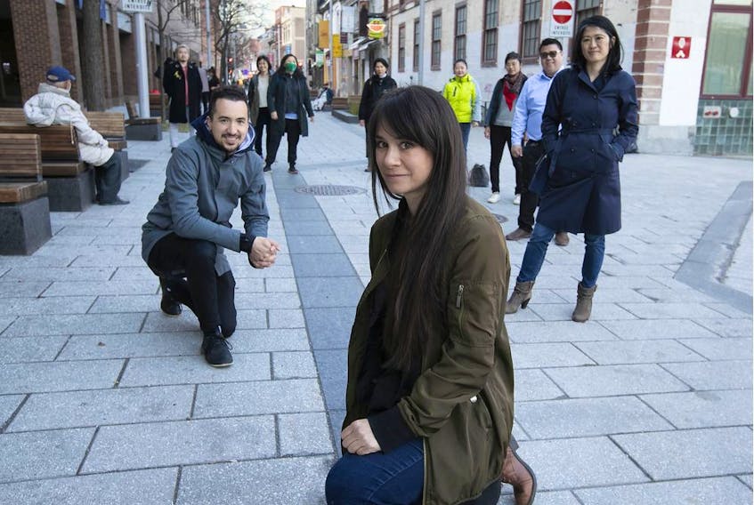 Karen Cho, foreground, and Jonathan Cha, left, with members of the Chinatown Working Group, are seen at the corner of de la Gauchetière and Côté Sts. in the heart of Montreal's Chinatown on Friday, April 23, 2021.