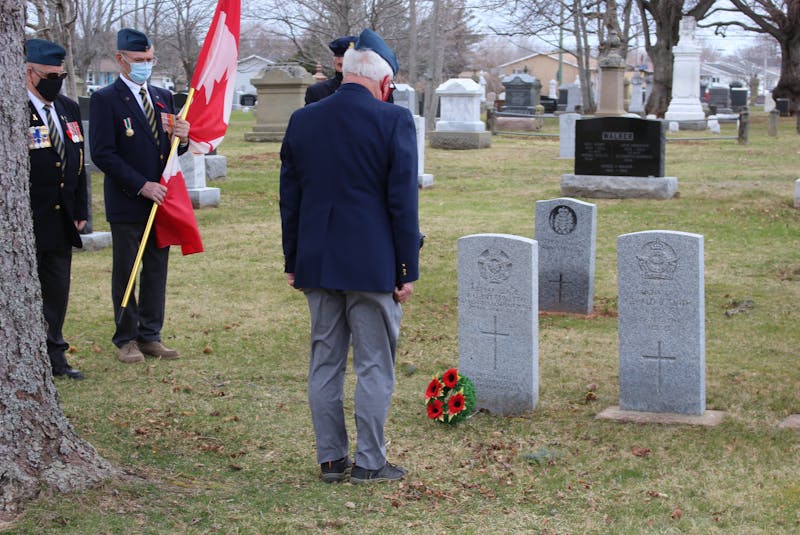 Roger Arsenault spending a moment of silence in front of Buttsworth's war grave after placing a poppy on the wreath. - Logan Plant
