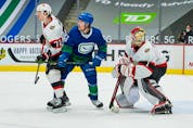  Senators defenceman Thomas Chabot battles Vancouver Canucks forward Brock Boeser in front of Ottawa goalie Marcus Hogberg in the second period.